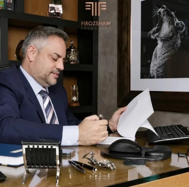 Advogado do Firozshaw Advogados analisando um contrato no escritório